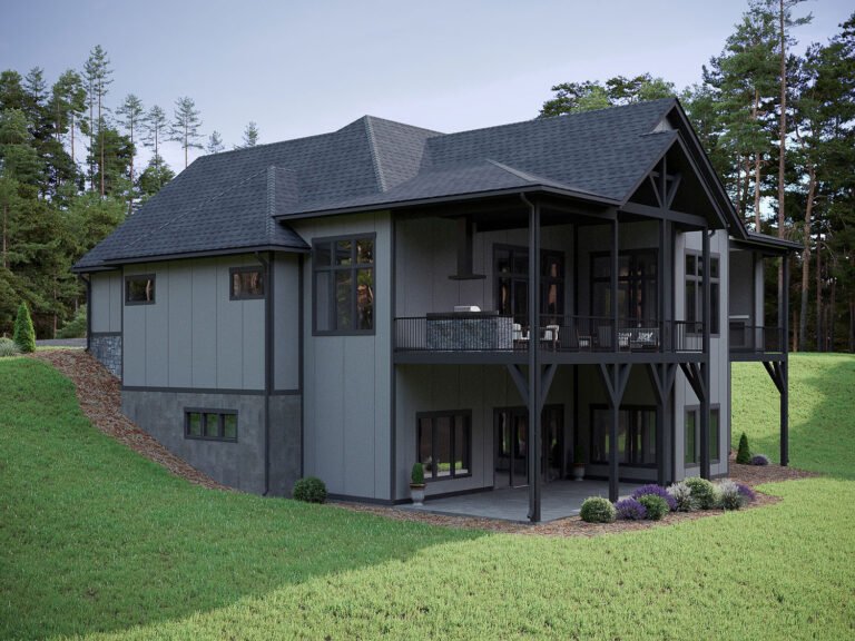 A modern, two-story cabin-style home nestled in a wooded, natural setting. The exterior features a dark gray color scheme with a large wraparound porch and numerous windows that allow natural light to flood the interior. The home is surrounded by lush greenery and landscaping, creating a serene and peaceful atmosphere.