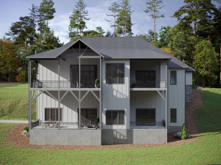 A modern, two-story cabin-style home nestled in a lush, forested setting. The house features a gray exterior with a prominent gable roof and large wrap-around porches on both levels. The surrounding landscape is dominated by tall pine trees and a grassy lawn, creating a serene and picturesque outdoor environment.