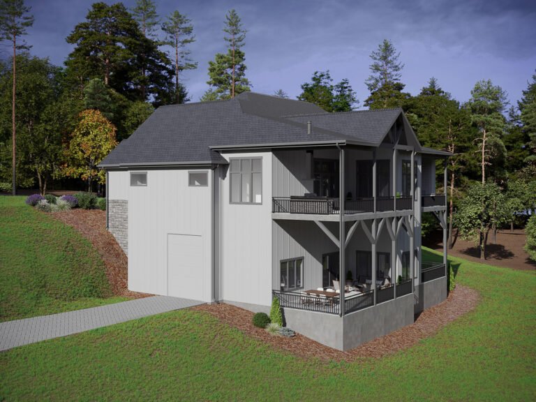 A modern, two-story home nestled in a lush, wooded landscape. The exterior features a combination of gray siding, stone accents, and a dark-colored roof. The home has a wraparound porch with wooden railings, providing ample outdoor living space. Tall pine trees and other greenery surround the property, creating a peaceful, natural setting.