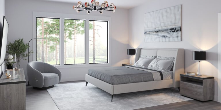 A luxurious modern bedroom with large windows overlooking a lush forest landscape. The room features a plush gray upholstered bed, a sleek chandelier, and minimalist decor elements that create a serene and sophisticated atmosphere. The neutral color palette and natural lighting contribute to the calming ambiance of the space.